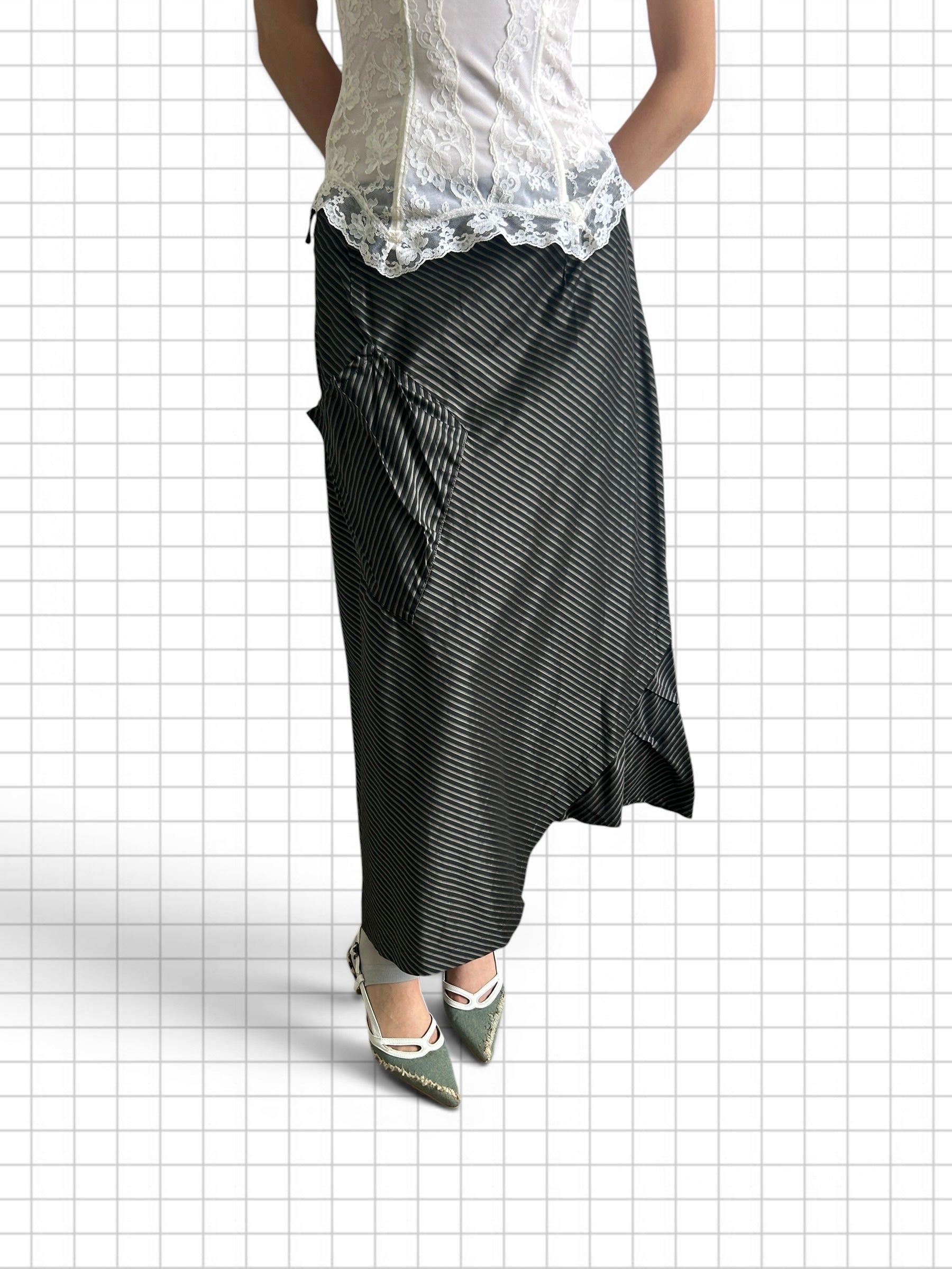 Wieder Wieder black maxi skirt with vertical pinstripes, asymmetrical hem, and patch pockets worn with a lace top.