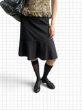 Wieder Wieder black pinstriped midi skirt with a flared hem, styled with black knee-high socks and ballet flats.