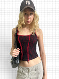 Wieder Wieder black and red lace corset tank top with bow detail worn by a blonde model with a cap and shoulder bag.
