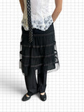 Wieder Wieder black tiered tulle midi skirt layered over pinstriped trousers with a white lace corset top.