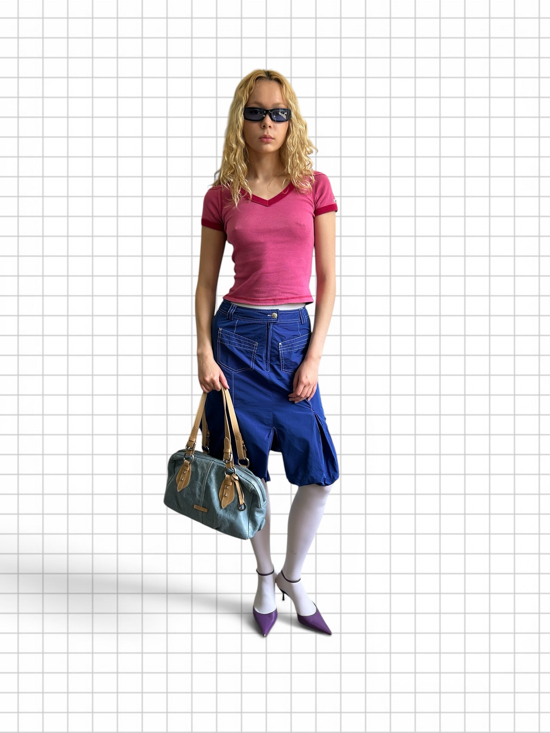 Wieder Wieder denim-look handbag with tan handles held by a model in a Y2K-inspired outfit against a grid background.