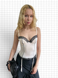 Wieder Wieder off-white corset bodice top with black lace trim and garter straps worn by a blonde model