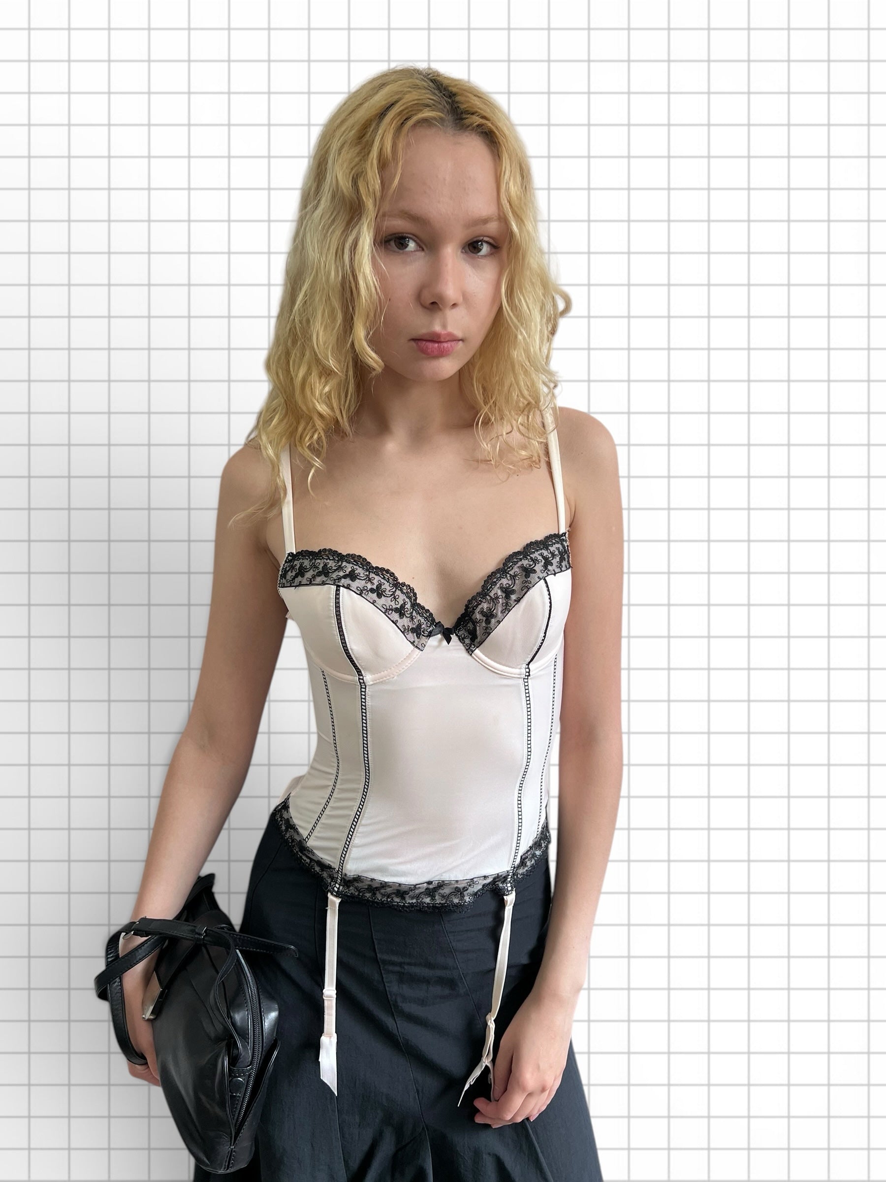 Wieder Wieder off-white corset bodice top with black lace trim and garter straps worn by a blonde model