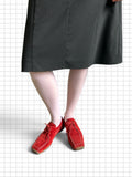 Wieder Wieder red suede lace-up shoes with a square toe, worn with white tights and a dark pinstripe skirt.