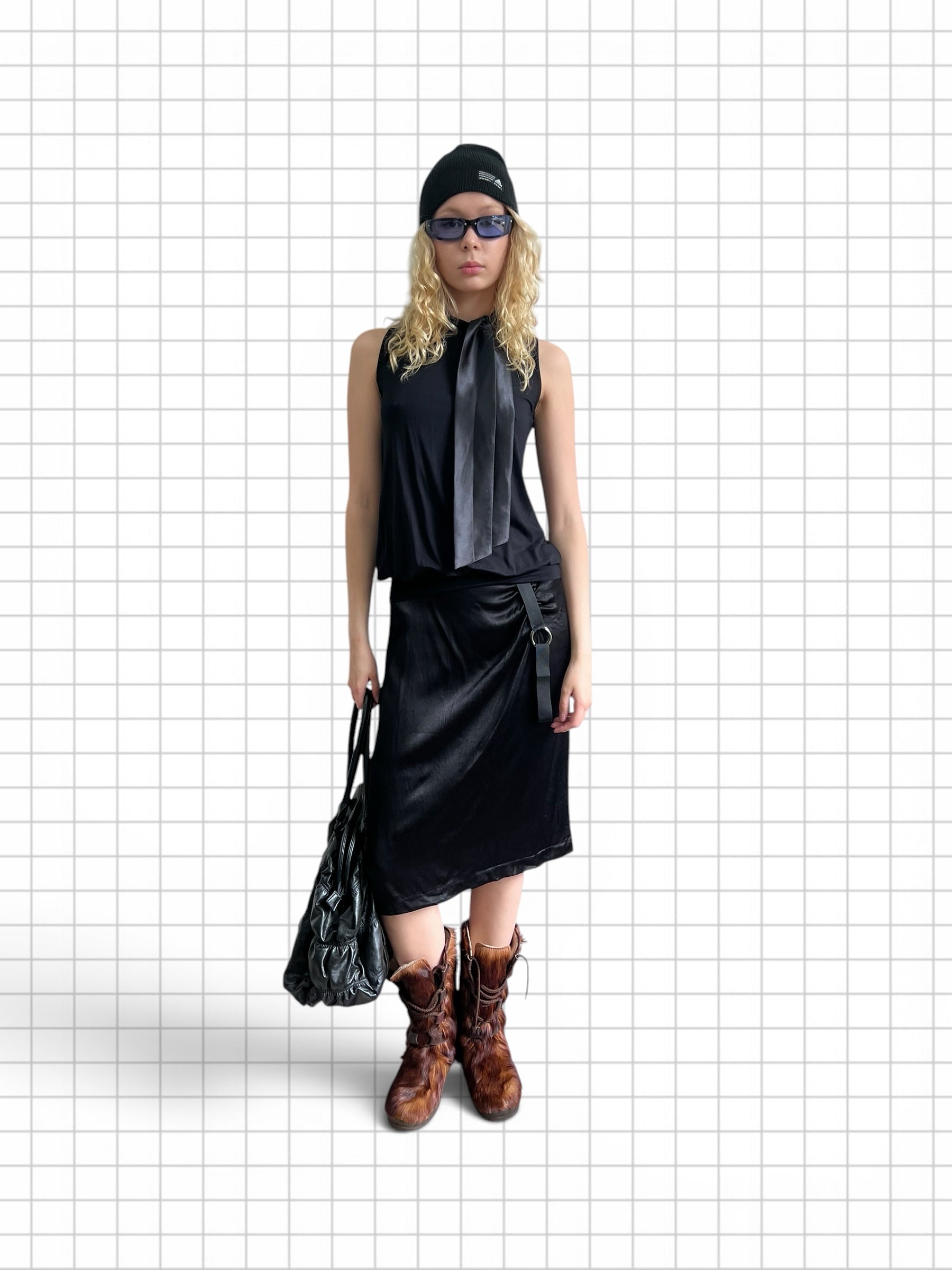 Wieder Wieder black midi skirt with side ring detail worn by a model with a black top, beanie, and brown boots.