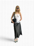 Wieder Wieder striped maxi skirt in black with asymmetric hem and pockets, worn by a model with a white lace top.
