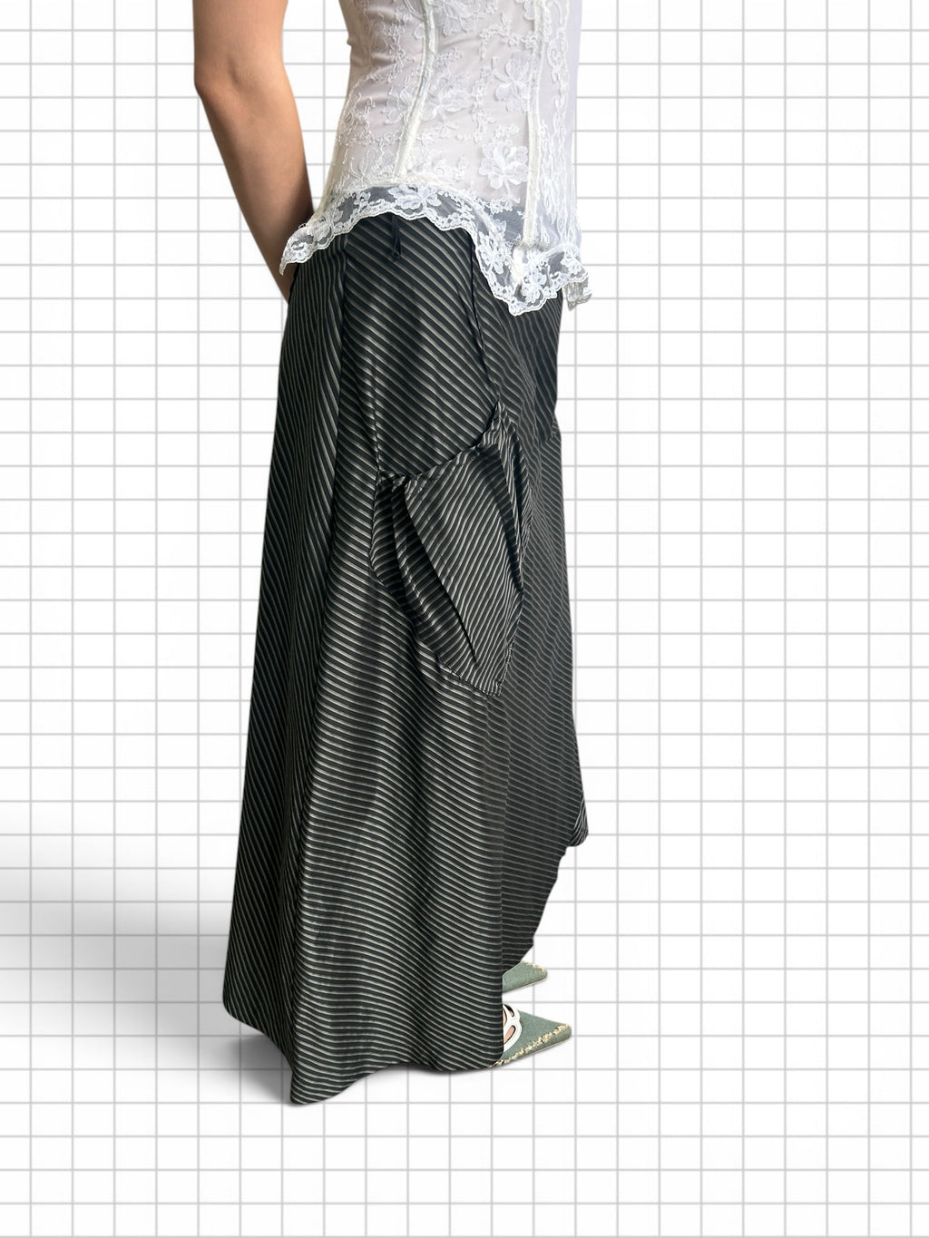 Wieder Wieder black maxi skirt with white pinstripes, featuring an asymmetrical hem and side pockets, worn with a lace top