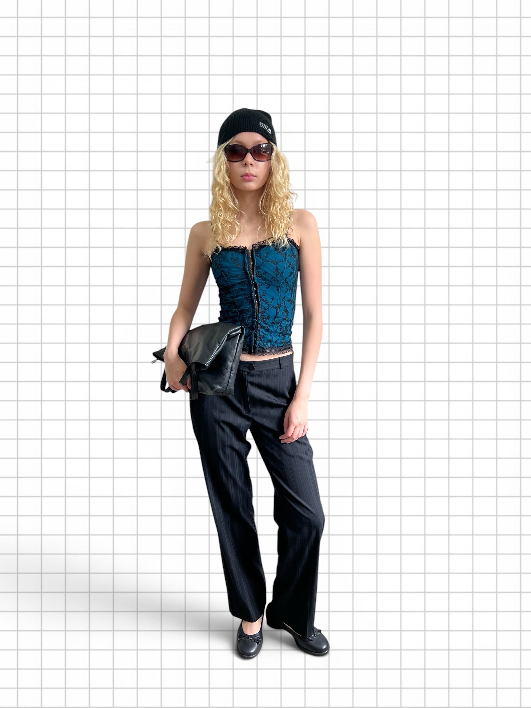 Wieder Wieder teal corset top with black floral lace overlay, worn by a blonde model with black trousers and beanie.